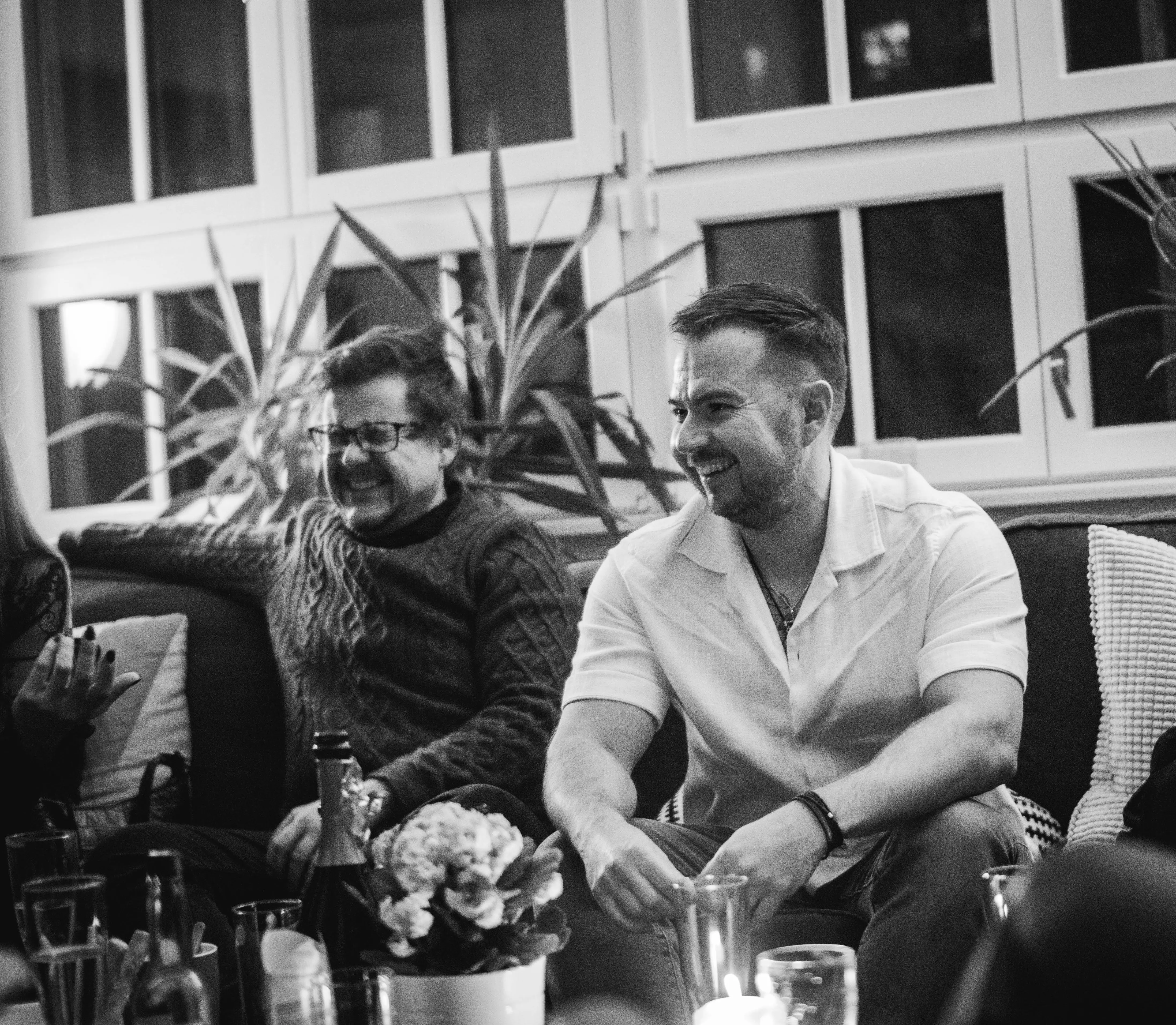 Stephan und Stefan sitzen auf der Couch und lachen (schwarz/weiß Foto)