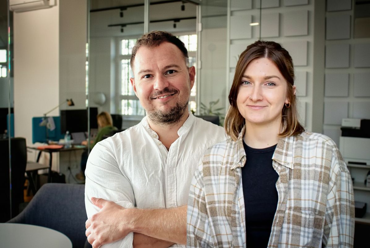 Mann und Frau lächeln in einem modernen Büro.