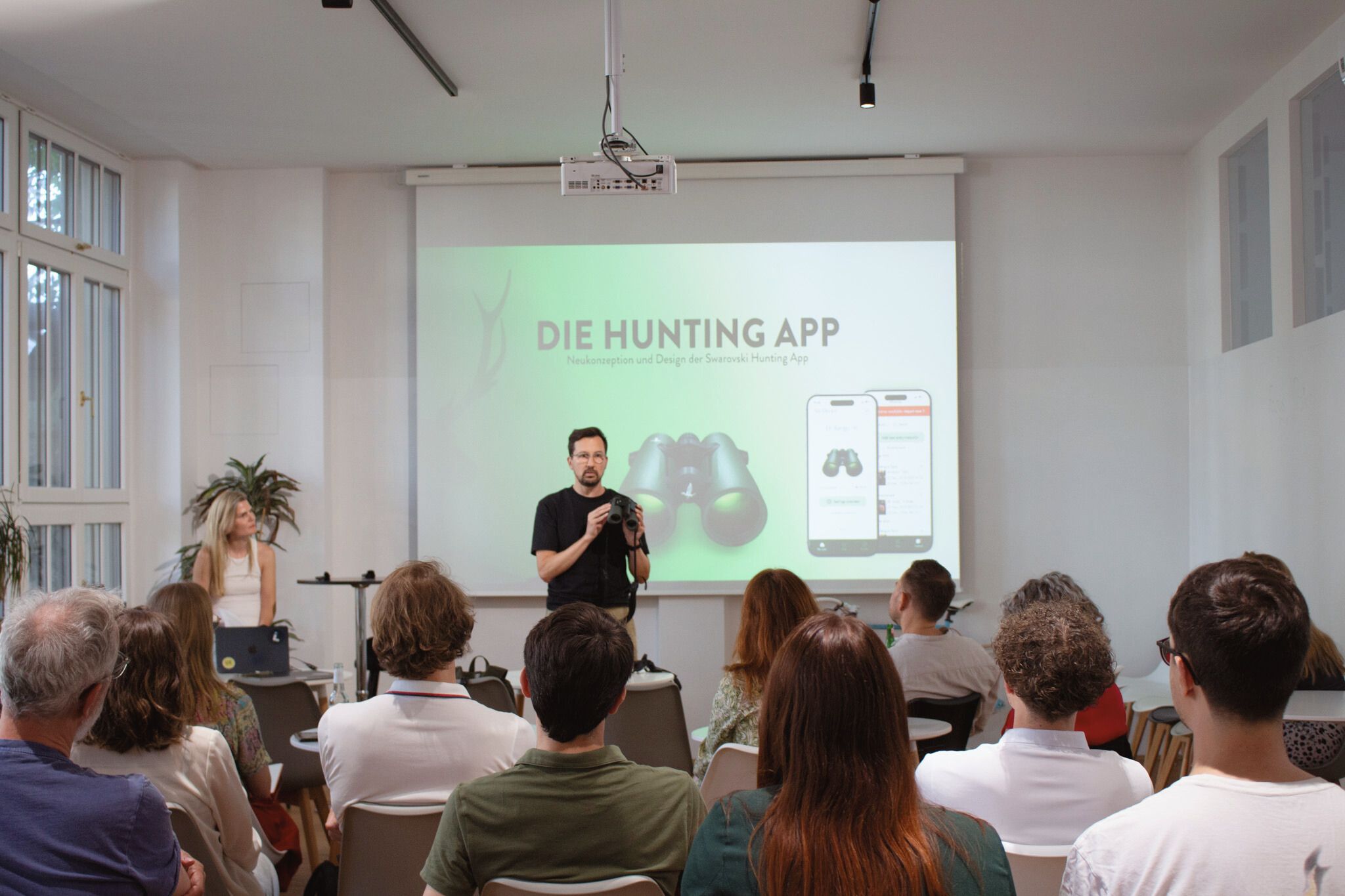 Christian mit AX Visio in der Hand, Co Speakerin Susanne im Hintergrund