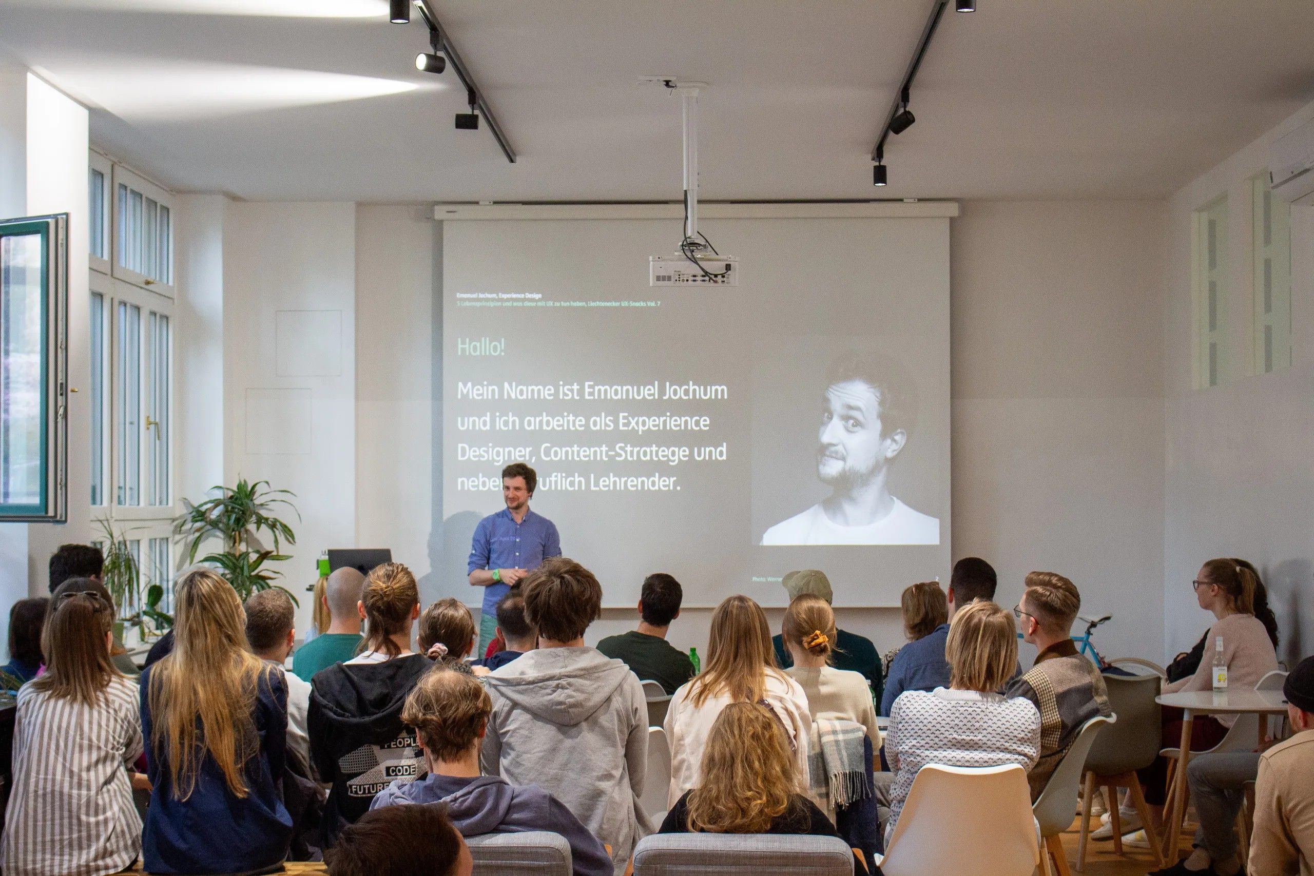 Emanuel Jochum vor der UX Snacks Community
Im Hintergrund eine Vorstellungs-Slide seiner Person
